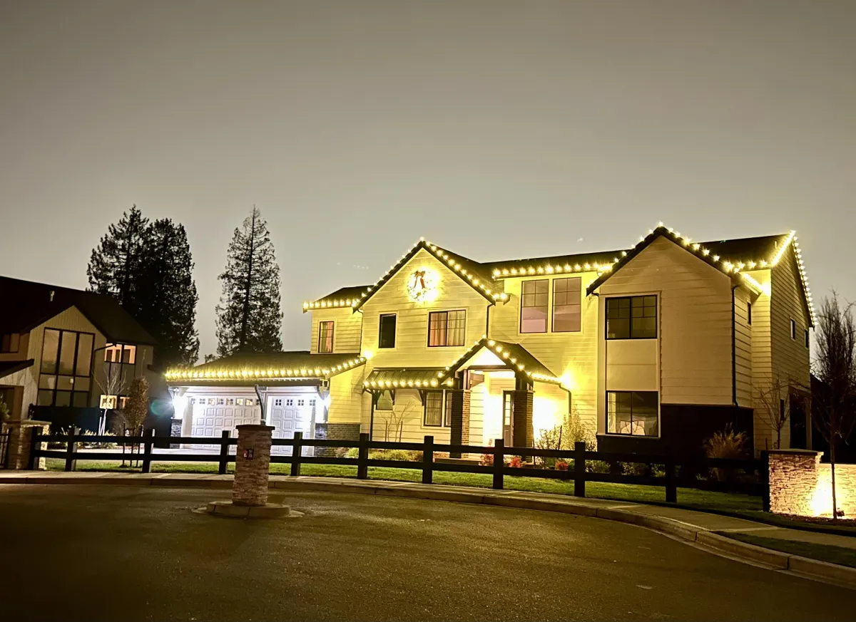 Large home with roofline holiday lights and pathway lighting