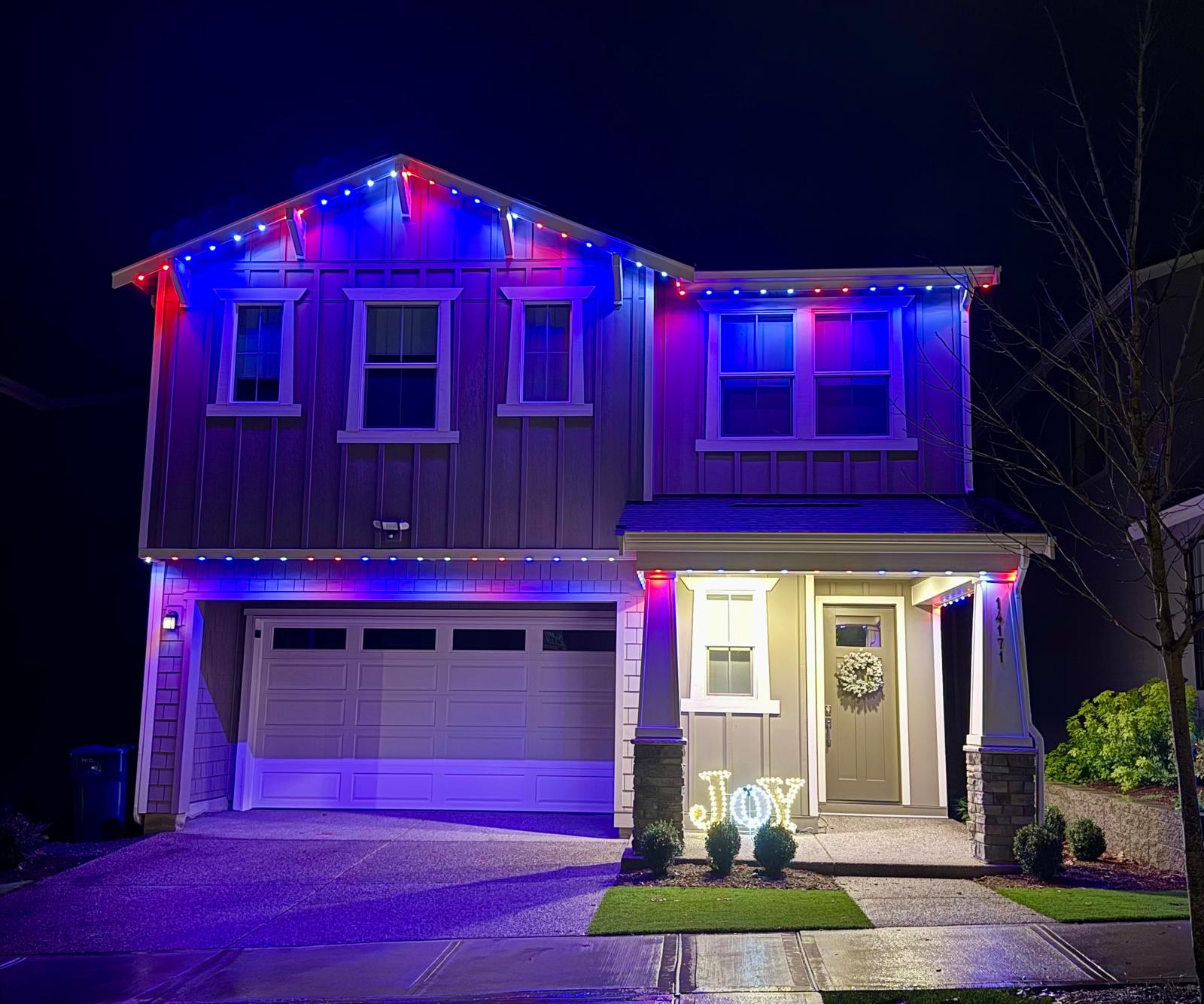 Craftsman home with red, white and blue permanent lights along the roofline